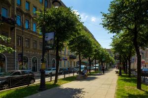 a street with trees and buildings in a city at Nevsky Grand Apartments in Saint Petersburg