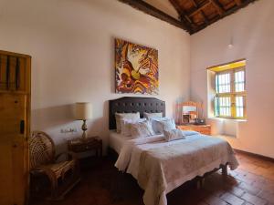 a bedroom with a bed and a painting on the wall at Hotel Boutique Casa de Los Santos Reyes Valledupar in Valledupar +105 photos