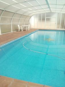 a large swimming pool with blue water at alojamiento temporal El Sotillo in Cuenca