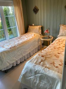 two beds in a room with a window at Verningen Apartment in Larvik