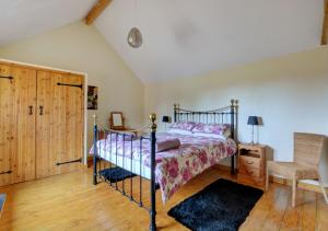 ein Schlafzimmer mit einem Bett und einem Stuhl in der Unterkunft The Hay House in Thursford