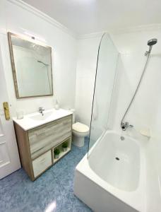 een badkamer met een wastafel, een bad en een toilet bij A casa do pai in Pontevedra