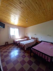 um quarto com 2 camas e um tecto de madeira em La Primavera em San Salvador de Jujuy