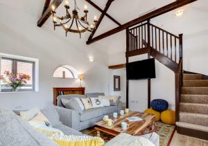 a living room with a couch and a staircase at The Hayloft in Tatterford