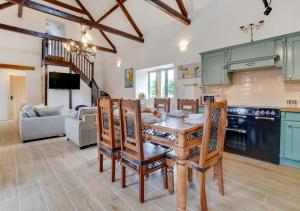 a kitchen and living room with a wooden table and chairs at The Hayloft in Tatterford