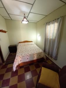 a bedroom with a bed and a checkered floor at La Primavera in San Salvador de Jujuy