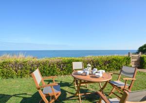 a table and chairs with the ocean in the background at The Lookout -Cromer in Cromer