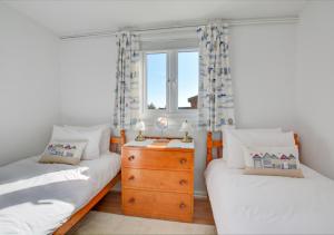 two twin beds in a room with a window at The Lookout -Cromer in Cromer