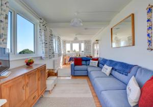 a living room with a blue couch and a tv at The Lookout -Cromer in Cromer