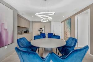 ein Esszimmer mit einem Tisch und blauen Stühlen in der Unterkunft HYDE HOUSE - Luxury Waterfront 2BR 2BA Apartment Suite with direct ocean view, roof top pool, resort amenities in Hollywood + 51 Fotos