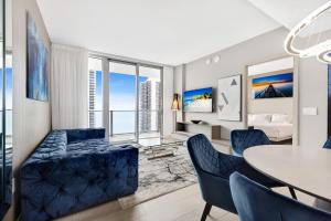 ein Wohnzimmer mit einem Tisch und blauen Stühlen in der Unterkunft HYDE HOUSE - Luxury Waterfront 2BR 2BA Apartment Suite with direct ocean view, roof top pool, resort amenities in Hollywood
