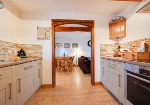 a kitchen with white cabinets and a dining room at The Maltings in Ludham