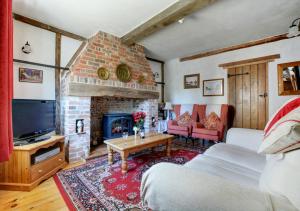 a living room with a couch and a fireplace at The Old Coach House in Cawston