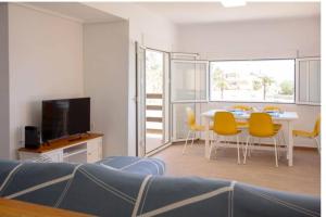 a living room with a table and yellow chairs at The perfect holiday apartment with fantastic views in Faro de Cullera