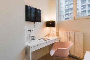 een kamer met een wit bureau en een tv aan de muur bij Sweet Inn - Porta Romana in Milaan