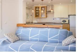 a kitchen with a blue couch in a kitchen at The perfect holiday apartment with fantastic views in Faro de Cullera
