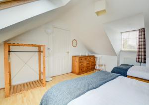 a bedroom with a bed and a dresser in a attic at The Old Post Room in Salhouse