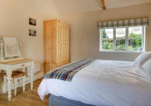 a bedroom with a bed and a desk and a window at The Old School House in Reepham