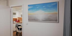 a painting hanging on a wall next to a kitchen at Luksusowy Apartament Nad Zalewem in Serock