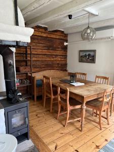 ein Esszimmer mit einem Holztisch und einem Holzofen in der Unterkunft Brännkärrstorpet B&B in Knivsta