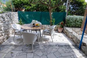 a table and chairs in a patio with a tree at Art & Gallery Vacation Home in Korčula