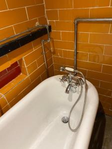 曼徹斯特的住宿－The Bunker，浴室设有浴缸和淋浴。