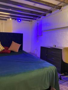 a bedroom with a bed and a desk and purple lights at The Bunker in Manchester
