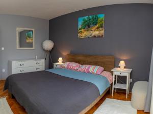een slaapkamer met een bed en een tafel met een stoel bij Art & Gallery Vacation Home in Korčula