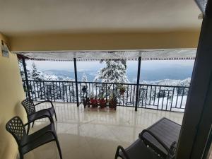 Habitación con balcón con vistas a las montañas cubiertas de nieve. en Smart Hill - Live The Nature en Dalhousie