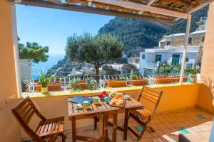 un tavolo e sedie su un balcone con vista sull'oceano di Estate4home - Angolo di Paradiso a Positano