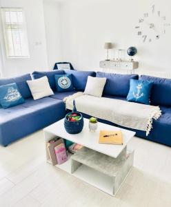 Sofá azul en la sala de estar con mesa en Seafront Apartment en Portsmouth