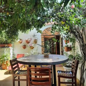a table and chairs in a patio with plants at Hotel Boutique Casa de Los Santos Reyes Valledupar in Valledupar