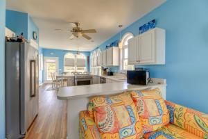 uma cozinha e sala de estar com paredes azuis e um sofá em Waterfront Emerald Isle Home with Dock Access! em Emerald Isle