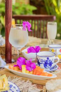 un tavolo con un piatto di frutta e un bicchiere d'acqua di Hotel Boutique Casa de Los Santos Reyes Valledupar a Valledupar