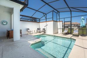 uma piscina numa casa com tecto de vidro em Luxury Decor 5 BR townhome with pool SL4928 em Kissimmee