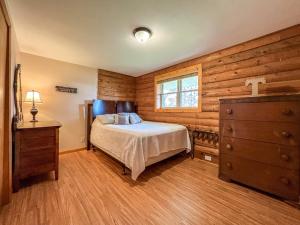 a bedroom with a bed and a dresser and a window at Elkhorn 3 Bedroom 2 Bathroom Log Cabin Sleeps 8 - Lincoln Log Cabin in Elkhorn