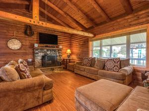a living room with couches and a fireplace in a cabin at Elkhorn 3 Bedroom 2 Bathroom Log Cabin Sleeps 8 - Lincoln Log Cabin in Elkhorn