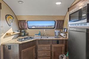 an rv kitchen with a sink and a window at JT Village Campground - Lil Miss Daisy in Joshua Tree