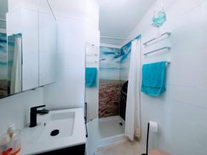 een witte badkamer met een douche en een wastafel bij Le bonheur entre Lac et Mer in Le Barcarès