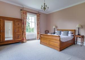 a bedroom with a wooden bed and a window at Vere Lodge Garden Wing 
