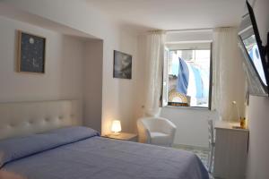 una camera con letto, finestra e sedia di Casa Bianca Amalfi ad Amalfi
