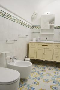 e bagno con servizi igienici, lavandino e vasca. di Casa Bianca Amalfi ad Amalfi