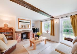 ein Wohnzimmer mit einem Sofa und einem Kamin in der Unterkunft Watts Cottage in Upton