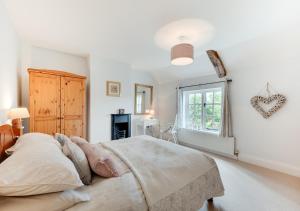 ein Schlafzimmer mit einem großen Bett und einem Fenster in der Unterkunft Watts Cottage in Upton