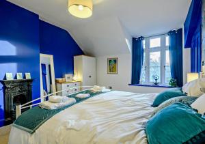 a blue bedroom with a large bed with blue walls at Warborough House East in Kelling