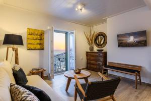 a living room with a couch and a table and a piano at Blueisla Sea View Suite A in Mikonos