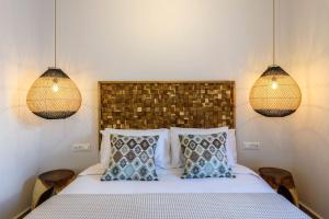 a bedroom with a bed with two lamps and two pillows at Blueisla Sea View Suite A in Mikonos