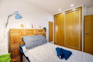 a bedroom with a bed and a wooden door at Apartamento cerca del hospital Virgen de la Arrixaca in Murcia