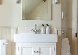 a bathroom with a white sink and a mirror at Willow Cottage in Wighton