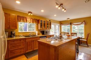 a large kitchen with wooden cabinets and a counter top at Empire Vacation Rental with Fire Pit and Gas Grill! in Empire